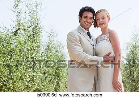 Stock Image - Newlyweds embracing, portrait. Fotosearch