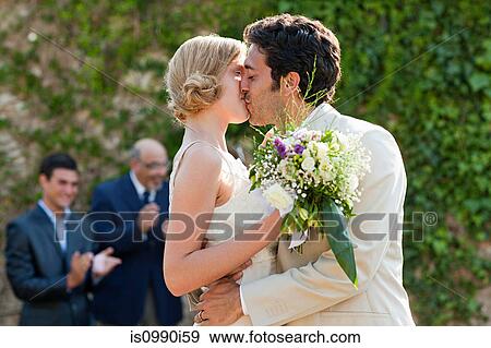 Newlyweds kissing at marriage ceremony View Large Photo Image Stock Photo - Newlyweds kissing at marriage ceremony. Fotosearch