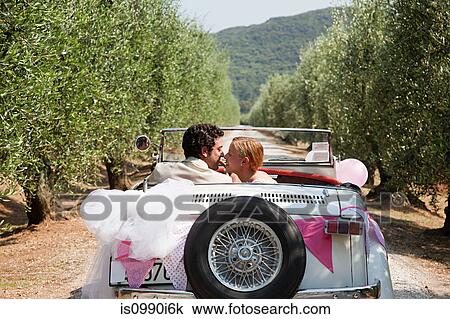 Newlyweds kissing in classic car View Large Photo Image Stock Image - Newlyweds kissing in classic car. Fotosearch