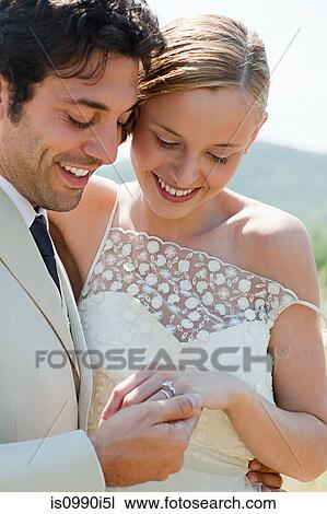 Newlyweds looking at wedding ring View Large Photo Image Stock Image - Newlyweds looking at wedding ring. Fotosearch