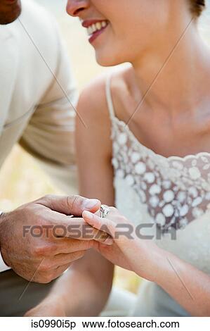 Newlyweds looking at wedding ring, close up View Large Photo Image Stock Photography - Newlyweds looking at wedding ring, close up. Fotosearch