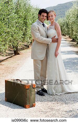 Newlyweds on country road with suitcase View Large Photo Image Stock Image - Newlyweds on country road with suitcase. Fotosearch