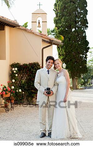 Portrait of newlyweds, groom holding vintage camera View Large Photo Image Stock Image - Portrait of newlyweds, groom holding vintage camera. Fotosearch