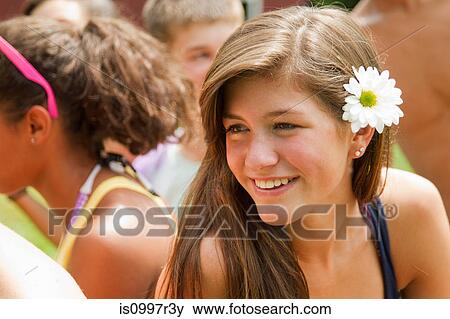 Stock Photo - Portrait of a teenage girl with a flower in her hair. Fotosearch