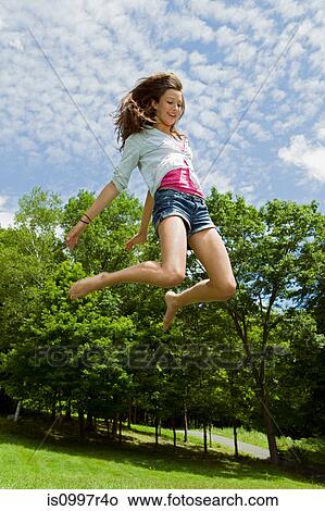 Teenage girl bouncing high in the air in the countryside View Large Photo Image Picture - Teenage girl bouncing high in the air in the countryside. Fotosearch