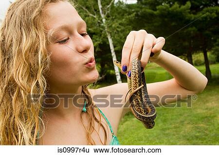 Stock Photograph - Teenage girl holding small snake. Fotosearch