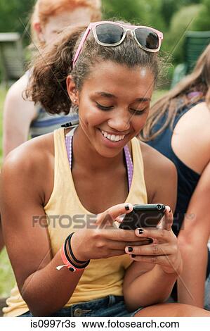 Teenage girl looking at a mobile phone in countryside View Large Photo Image Stock Photograph - Teenage girl looking at a mobile phone in countryside. Fotosearch