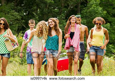 Stock Image - Teenagers going on a picnic together in the countryside. Fotosearch