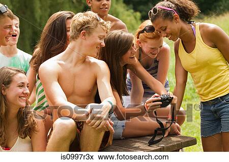 Teenagers reviewing photos together on a friend's camera View Large Photo Image Stock Photo - Teenagers reviewing photos together on a friend's camera. Fotosearch