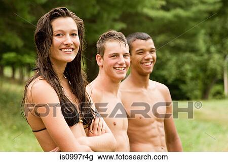 Stock Image - Three teenagers in swimming costumes relaxing together. Fotosearch
