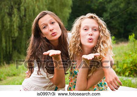Two teenage girls fooling around in the countryside and blowing kisses View Large Photo Image Stock Image - Two teenage girls fooling around in the countryside and blowing kisses. Fotosearch