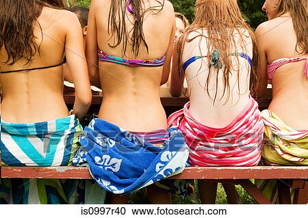 View of the backs of teenage girls sitting on a picnic table in bikinis View Large Photo Image Stock Image - View of the backs of teenage girls sitting on a picnic table in bikinis. Fotosearch