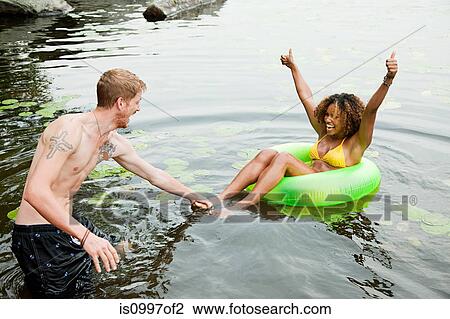 Couple playing on inflatable ring on lake View Large Photo Image Stock Image - Couple playing on inflatable ring on lake. Fotosearch