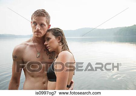Couple standing by lake View Large Photo Image Stock Photo - Couple standing by lake. Fotosearch