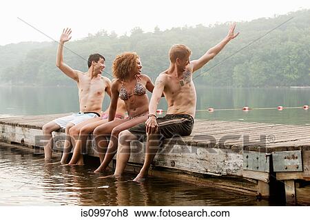 Friends turning to wave from pier on lake View Large Photo Image Stock Photo - Friends turning to wave from pier on lake. Fotosearch