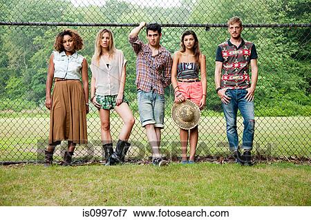 Portrait of friends standing against chain link fence View Large Photo Image Stock Photo - Portrait of friends standing against chain link fence. Fotosearch
