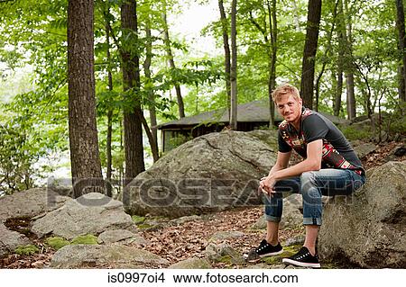 Portrait of mid adult man sitting in forest View Large Photo Image Picture - Portrait of mid adult man sitting in forest. Fotosearch