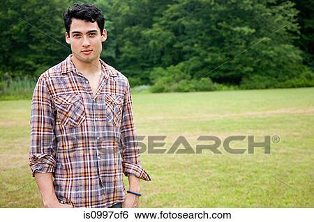 Stock Photograph - Portrait of young man in field. Fotosearch