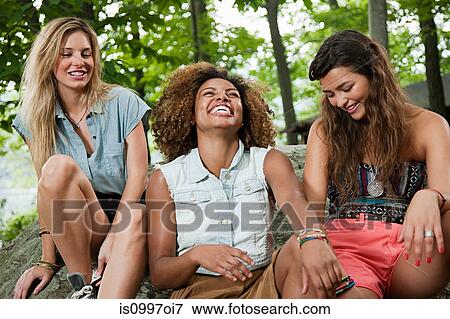 Three young women laughing in forest View Large Photo Image Stock Photo - Three young women laughing in forest. Fotosearch