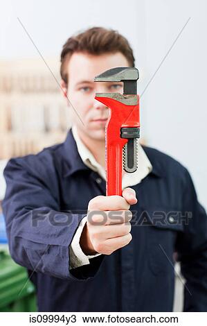 Apprentice plumber holding up adjustable wrench View Large Photo Image Stock Image - Apprentice plumber holding up adjustable wrench. Fotosearch