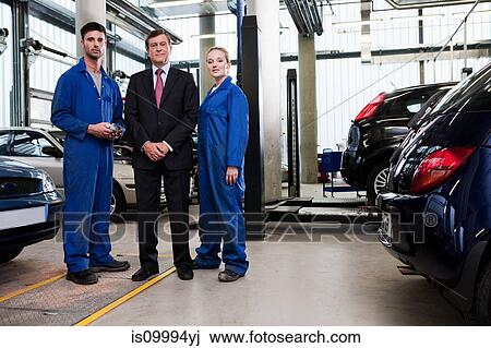 Businessman with mechanics in repair garage View Large Photo Image Stock Image - Businessman with mechanics in repair garage. Fotosearch