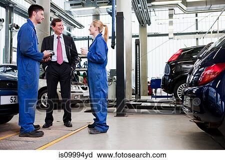 Businessman with two car mechanics in repair garage View Large Photo Image Stock Image - Businessman with two car mechanics in repair garage. Fotosearch