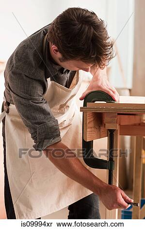 Carpenter adjusting clamp in workshop View Large Photo Image Stock Photography - Carpenter adjusting clamp in workshop. Fotosearch