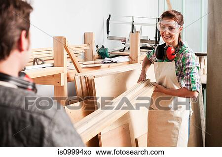 Carpenters carrying wood in workshop View Large Photo Image Picture - Carpenters carrying wood in workshop. Fotosearch