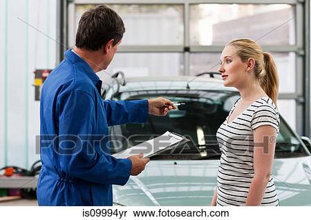 Mechanic discussing car with young woman View Large Photo Image Stock Photography - Mechanic discussing car with young woman. Fotosearch