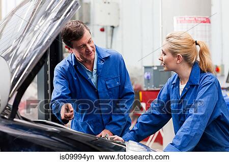 Mechanic disussing car engine with apprentice View Large Photo Image Picture - Mechanic disussing car engine with apprentice. Fotosearch