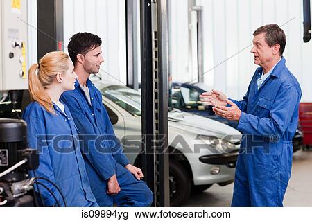 Stock Image - Mechanic talking with apprentices. Fotosearch