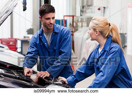 Mechanics disussing car engine View Large Photo Image Picture - Mechanics disussing car engine. Fotosearch
