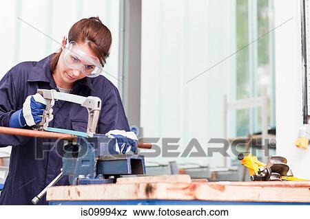 Plumber cutting into copper pipe in workshop View Large Photo Image Stock Photo - Plumber cutting into copper pipe in workshop. Fotosearch