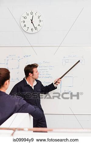 Professional plumber teaching apprentice in front of whiteboard View Large Photo Image Stock Photo - Professional plumber teaching apprentice in front of whiteboard. Fotosearch