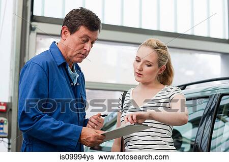 Woman pointing at mechanics clipboard View Large Photo Image Stock Photograph - Woman pointing at mechanics clipboard. Fotosearch