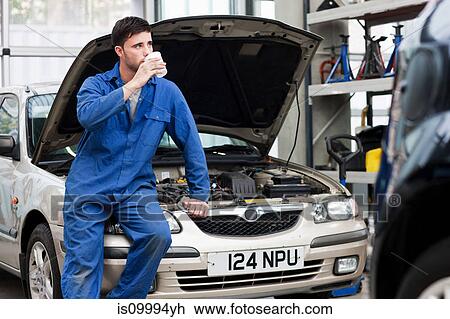 Young mechanic drinking coffee on car View Large Photo Image Stock Image - Young mechanic drinking coffee on car. Fotosearch