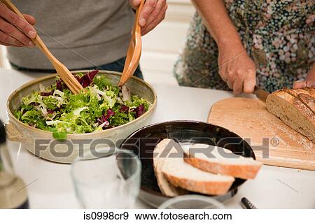 Stock Photo - Close-up of couple preparing food together. Fotosearch