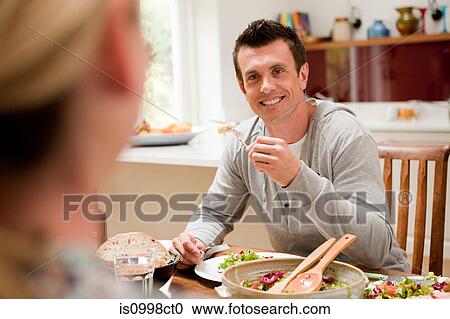 Couple eating healthy meal together at table View Large Photo Image Stock Image - Couple eating healthy meal together at table. Fotosearch
