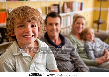 Stock Image - Family relaxing together in their living room. Fotosearch