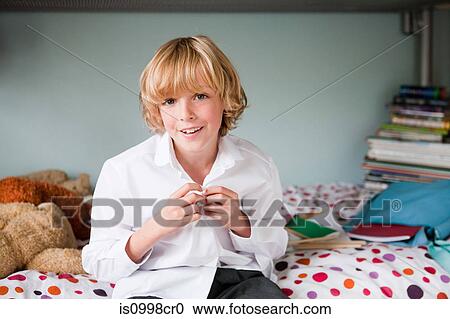 Young boy buttoning up his school shirt in his bedroom View Large Photo Image Stock Image - Young boy buttoning up his school shirt in his bedroom. Fotosearch