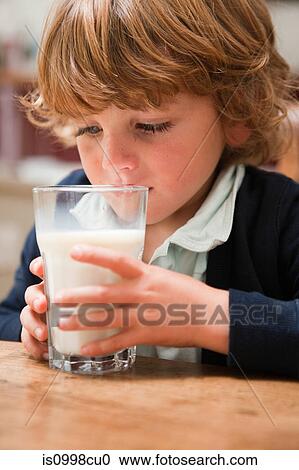 Young boy drinking a large glass of milk View Large Photo Image Stock Image - Young boy drinking a large glass of milk. Fotosearch