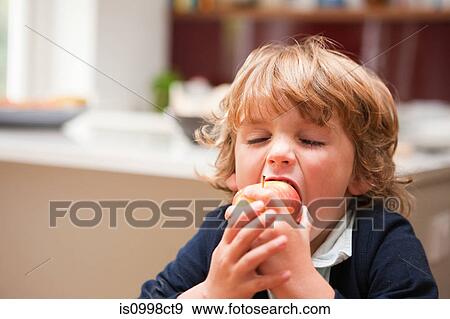 Young boy eating an apple View Large Photo Image Stock Photo - Young boy eating an apple. Fotosearch