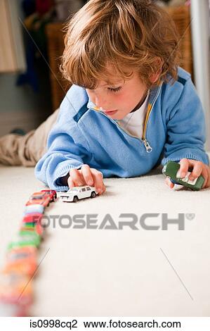 Young boy lining up toy cars in his bedroom View Large Photo Image Stock Image - Young boy lining up toy cars in his bedroom. Fotosearch