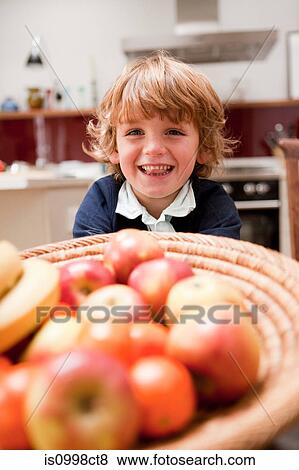 Young boy sitting at dining table with apples View Large Photo Image Stock Photo - Young boy sitting at dining table with apples. Fotosearch