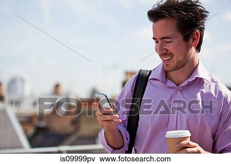 Stock Photo - Man looking at mobile phone. Fotosearch