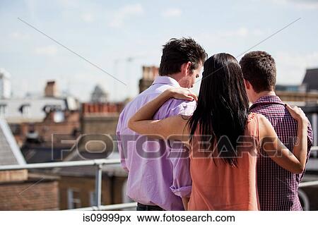 Three people looking at something together View Large Photo Image Stock Photo - Three people looking at something together. Fotosearch