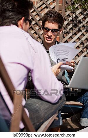 Stock Photograph - Two men having a relaxed meeting outside. Fotosearch