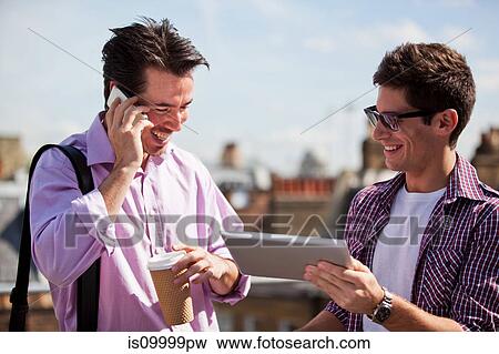 Stock Photo - Two men looking at a digital tablet. Fotosearch