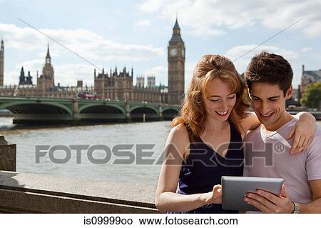 Picture - Young couple looking at a digital tablet. Fotosearch