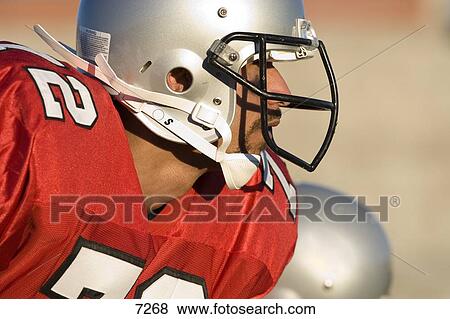 American Football Player Wearing Red Football Strip And Protective Helmet Close Up Profile Focus On Foreground Stock Photo 7268 Fotosearch